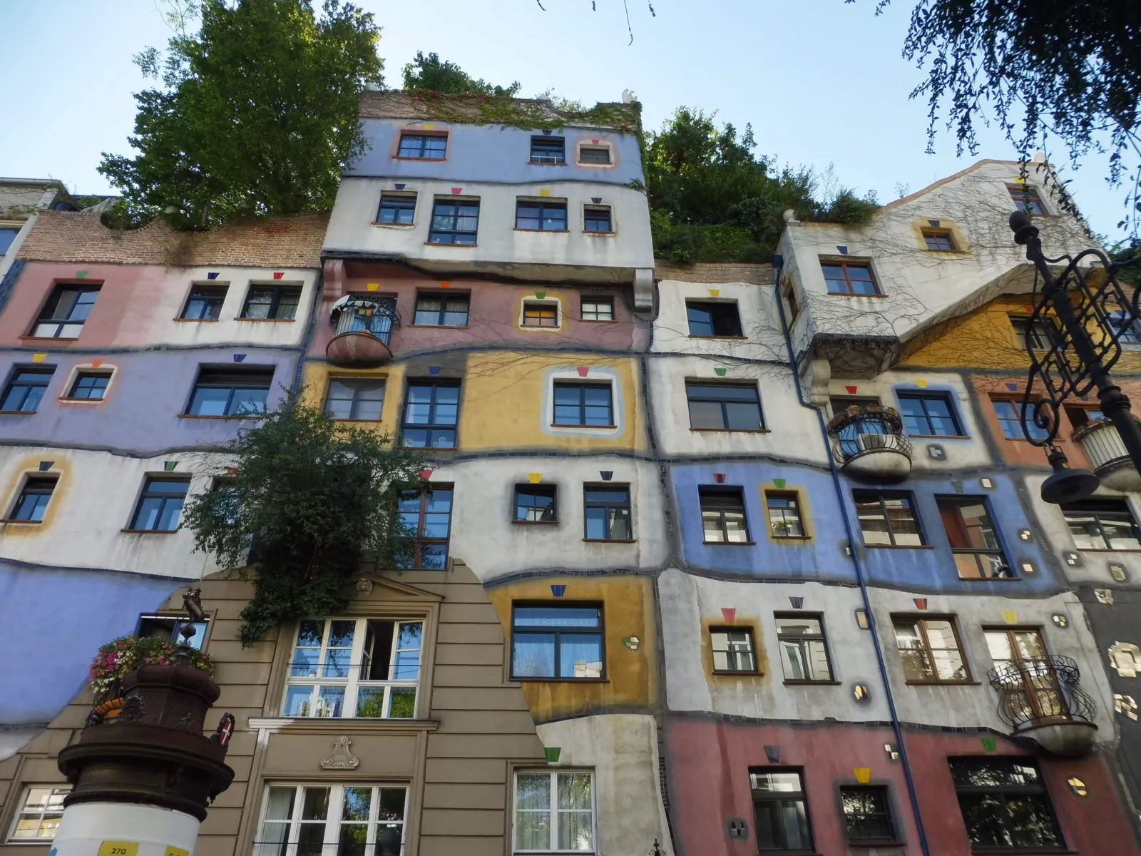Kolorowa fasada Hundertwasserhaus z drzewami rosnącymi na tarasach